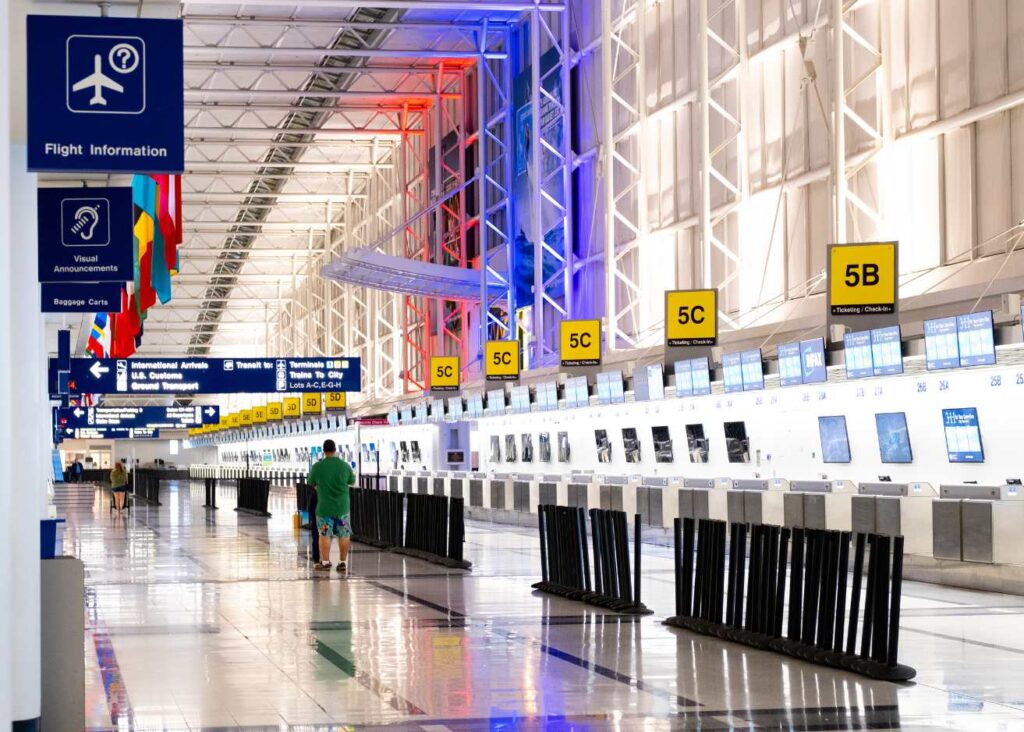 A long line of travelers moving through an airport terminal, showcasing the hustle and bustle of air travel.