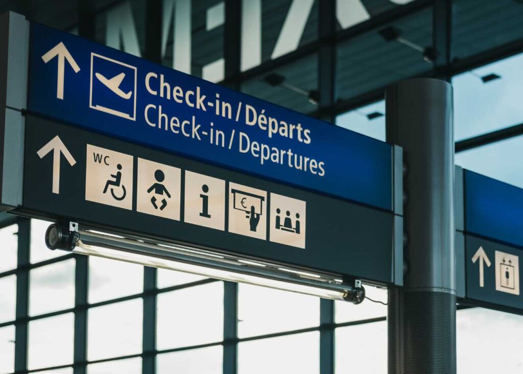 Check-in and check-in-depart signs displayed prominently at an airport, guiding travelers through the terminal.