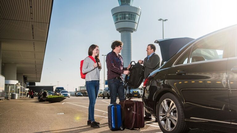 Three individuals standing beside a car, surrounded by luggage, ready for a journey or vacation.