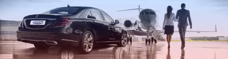 A black car parked beside an airplane on a tarmac, showcasing a contrast between land and air transportation.