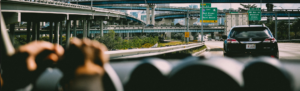 A car travels along a highway, showcasing a clear view of the road ahead and the surrounding landscape.