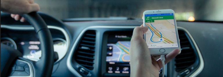 A driver using Google Maps on a car dashboard, showcasing navigation features and route planning.