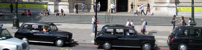 A diverse group of individuals gathered at a street corner, engaged in conversation and enjoying the urban atmosphere.