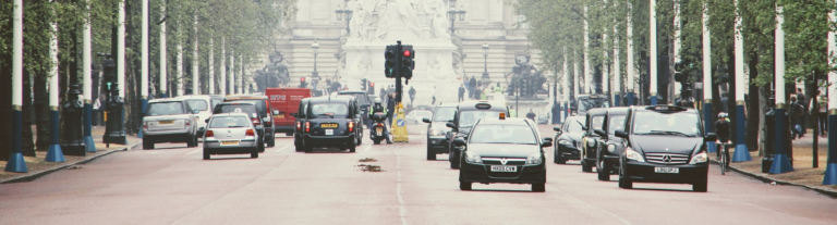 A busy street filled with various cars and trucks traveling in both directions.