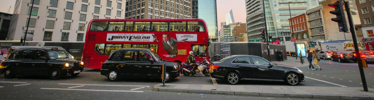 A red double-decker bus parked on a city street, showcasing its iconic design and vibrant color.