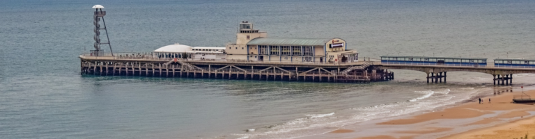 A scenic pier featuring a lighthouse at its end, standing tall against the backdrop of the sky and water.