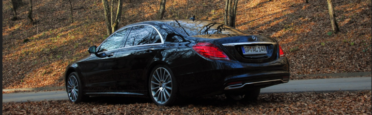 A Mercedes S-Class parked elegantly on the roadside, showcasing its luxury and design.