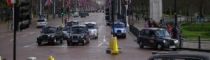 A busy street filled with numerous cars and a crowd of pedestrians moving along the sidewalks.