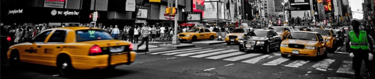 A bustling city street filled with taxis and cars navigating through traffic.