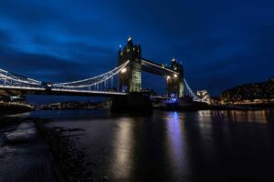 Tower Bridge illuminated at night, showcasing its architectural beauty against a dark sky.