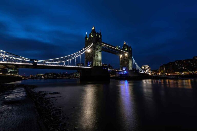 Tower Bridge illuminated at night, showcasing its architectural beauty against a dark sky.