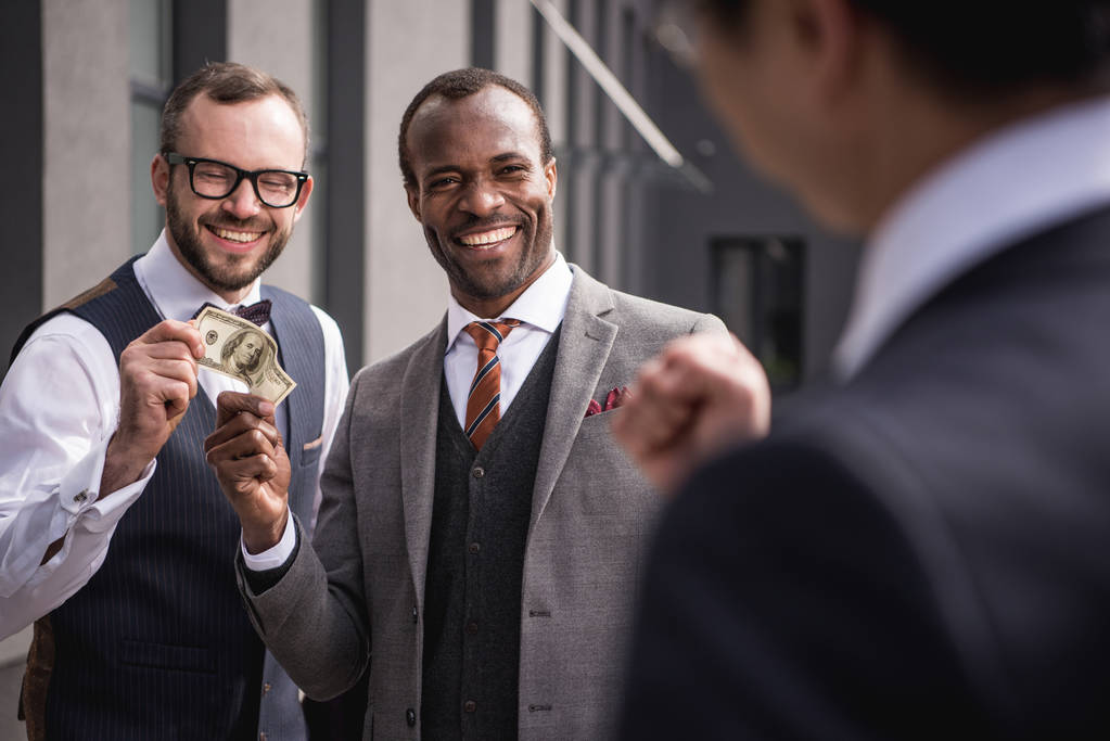 young smiling multiethnic businessmen in formalwear meeting outdoors, business team meeting