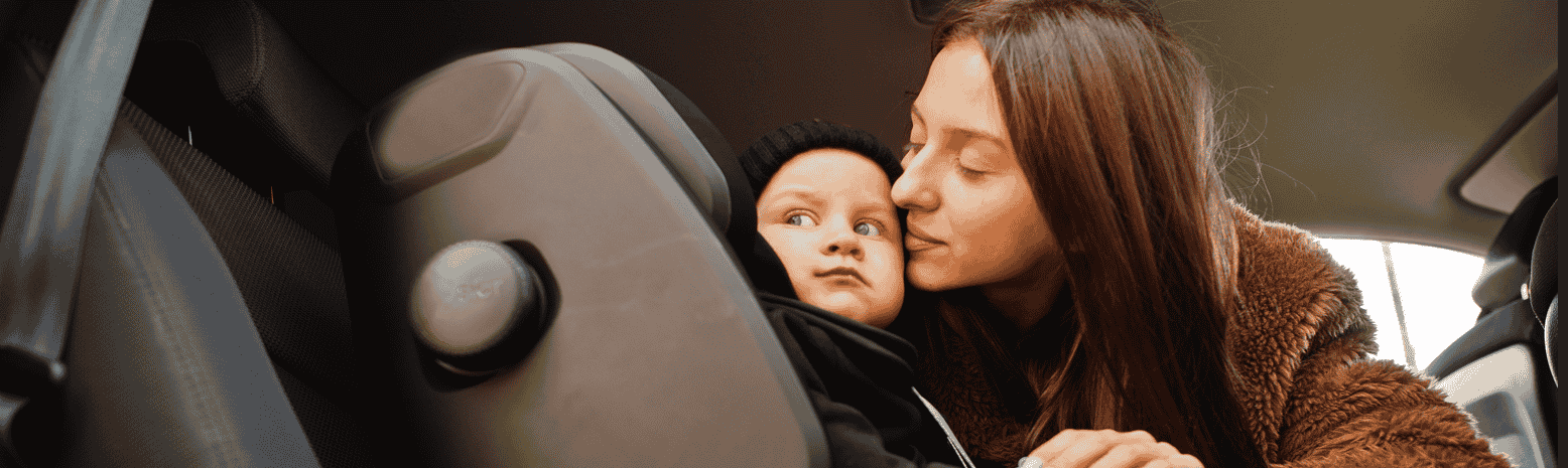 Young mother and child in car baby seat on chair safety driving concept