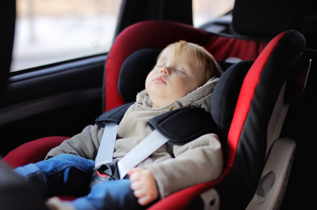 Portrait of toddler boy sleeping in car seat