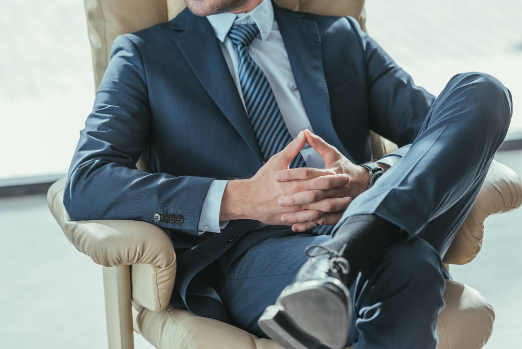 cropped-shot businessman relaxing luxury armchair