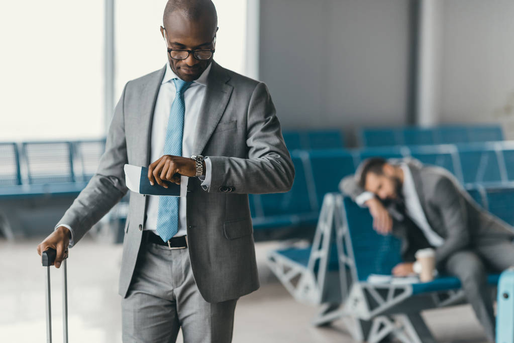 A person holding luggage at airport lobby
