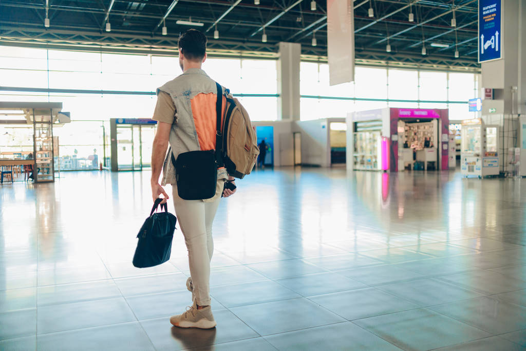 Man traveling by airplane. Young passenger waiting at the airport for a delayed flight