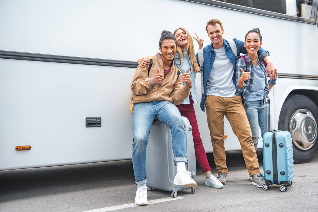 A group of friends smiling with luggage 