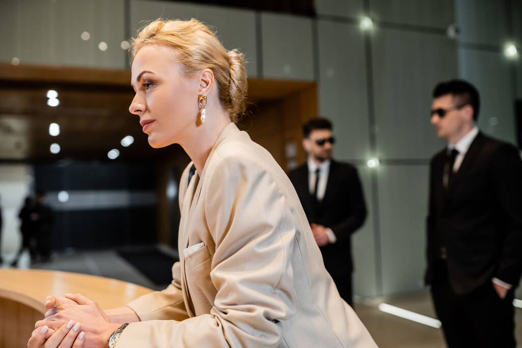 Woman in suit standing at reception desk