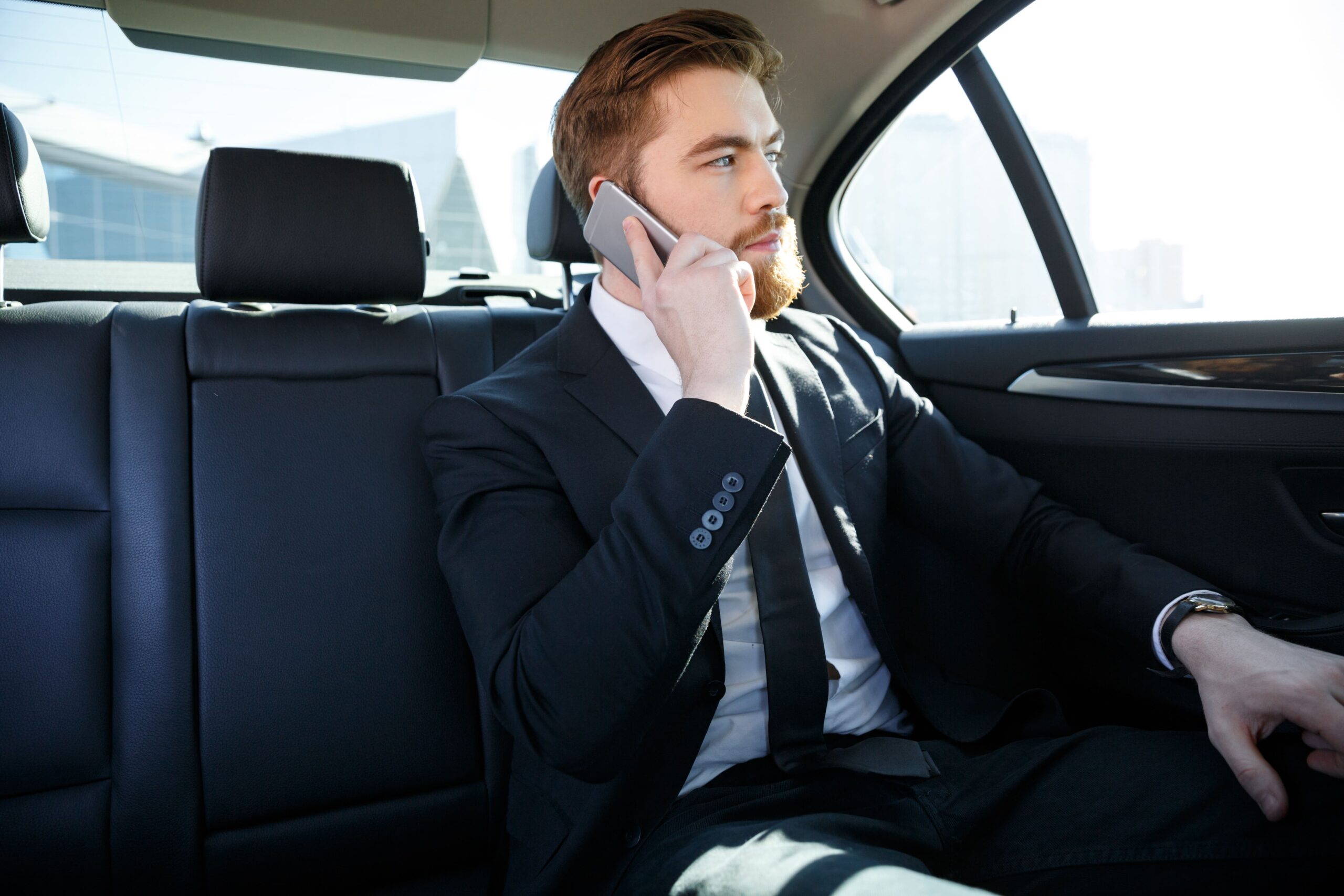 confident-bearded-businessman-talking-mobile-phone