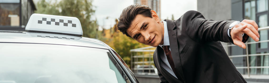 Man pointing at something beside a taxi