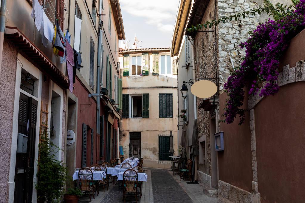 Narrow street with traditional houses and outdoor cafe 