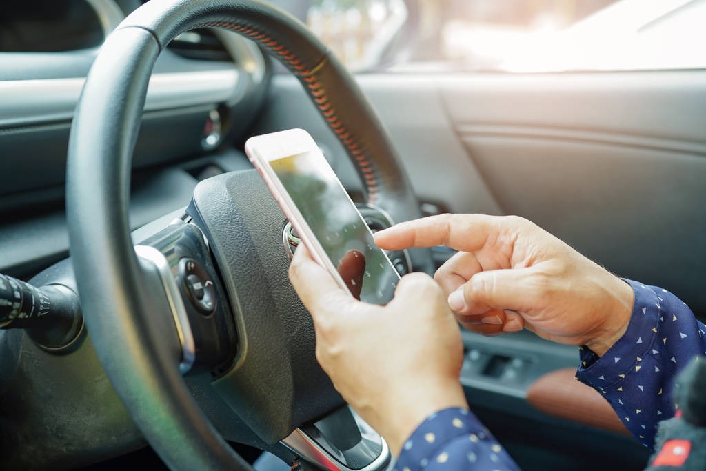 Person holding phone while sitting in the car