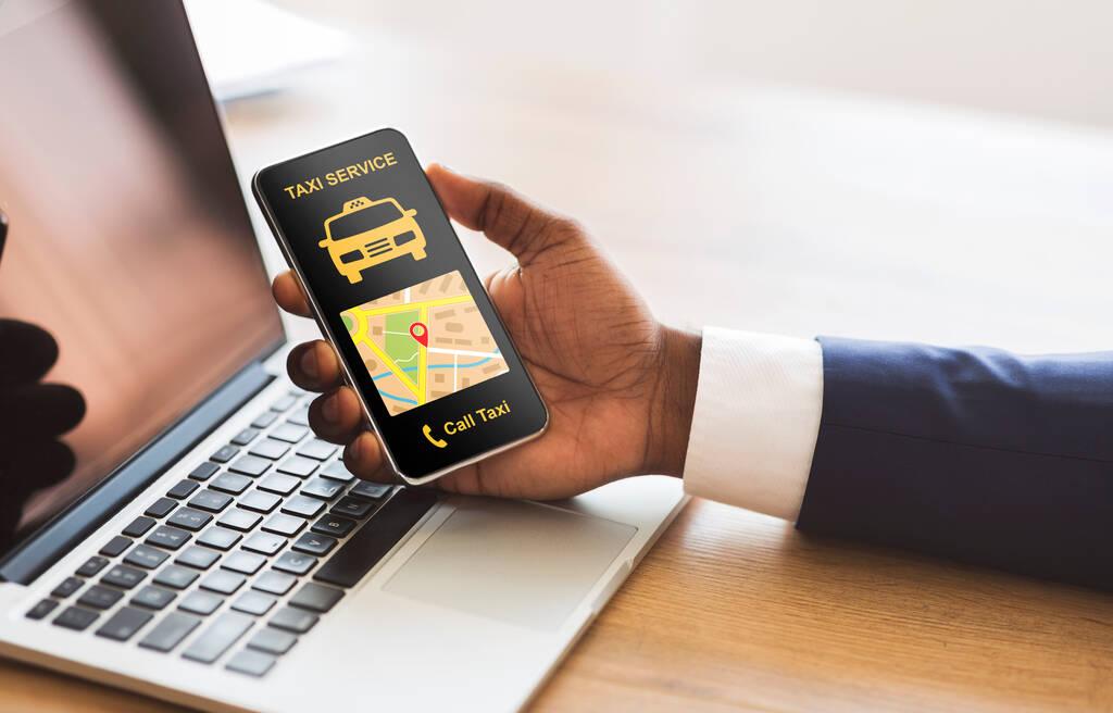 Businessman holding a smartphone featuring taxi app interface