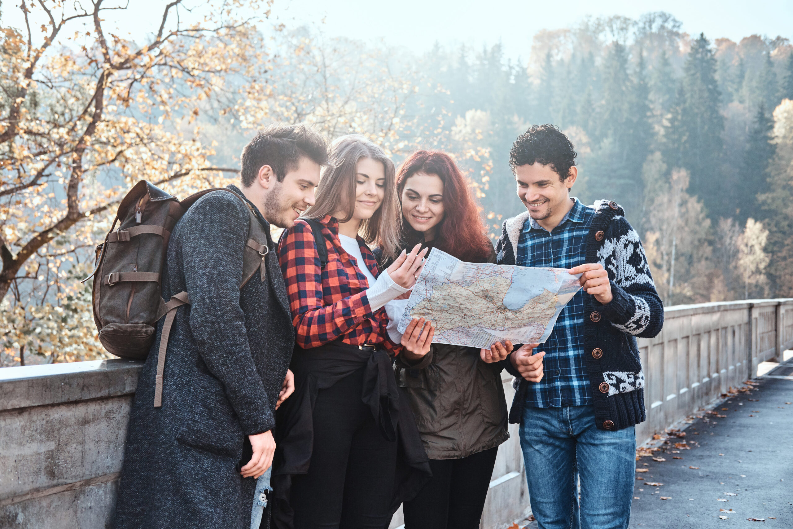 group-young-people-are-looking-map-where-they-are-while-walking-autumn-forest