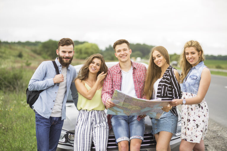 portrait-tourist-friends-holding-map-standing-front-car-outdoors